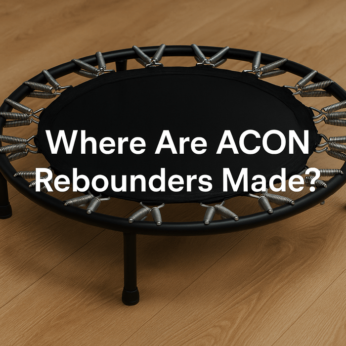 acon-rebounder-on-wooden-floor-with-metal-springs-and-black-mat-bold-white-text-in-centre-reading-where-are-acon-rebounders-made