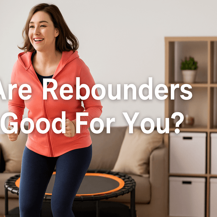 woman-smiling-bouncing-on-rebounder-trampoline-in-living-room-wearing-pink-hoodie-showing-rebounder-trampoline-benefits-for-fitness-heart-health-joint-support-and-stress-relief
