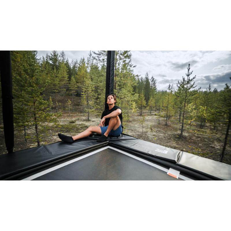 ACON-X-Trampoline-with-adult-sitting-beside-forest-view
