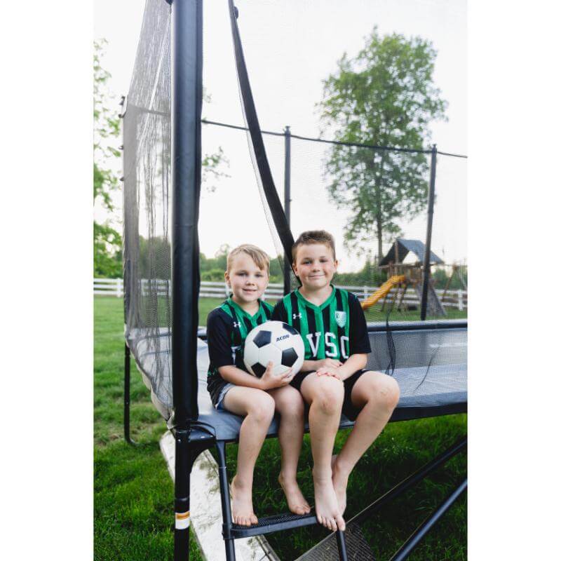 ACON-X-Trampoline-with-children-sitting-by-football-goal