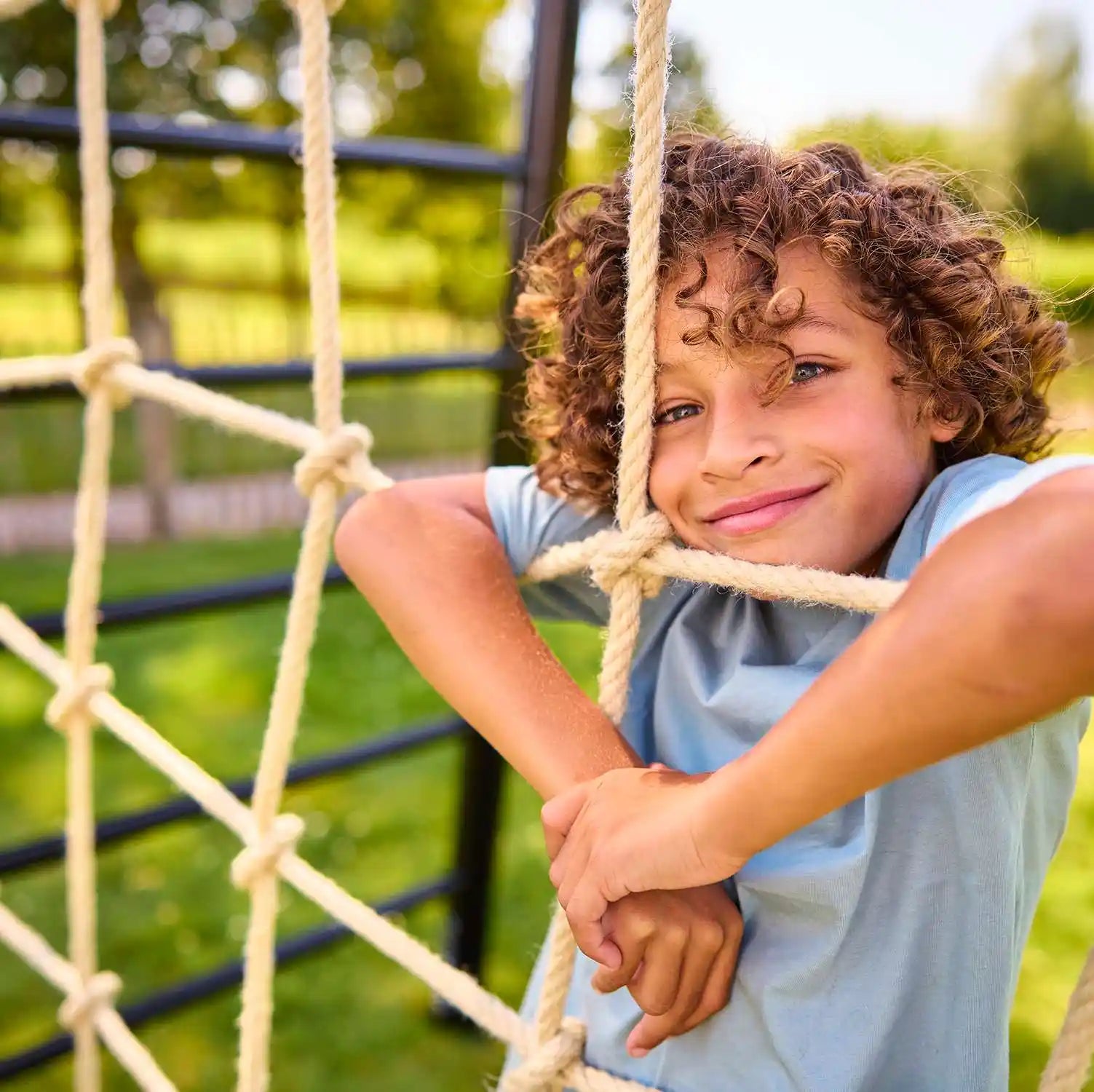 BERG Playbase climbing net with boy enjoying in the garden
