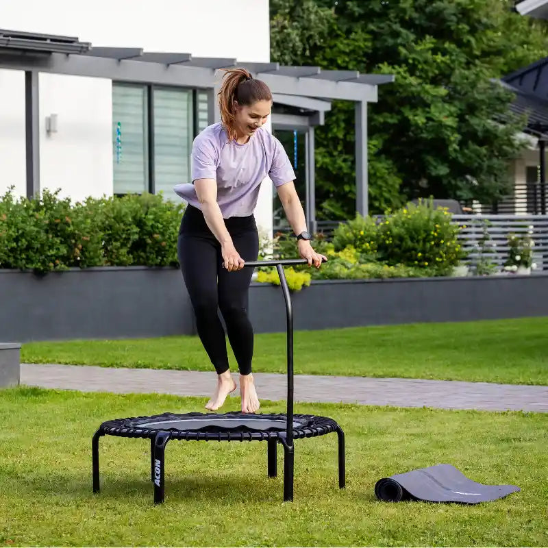 Woman-bouncing-on-ACON-rebounder-with-handle-in-garden