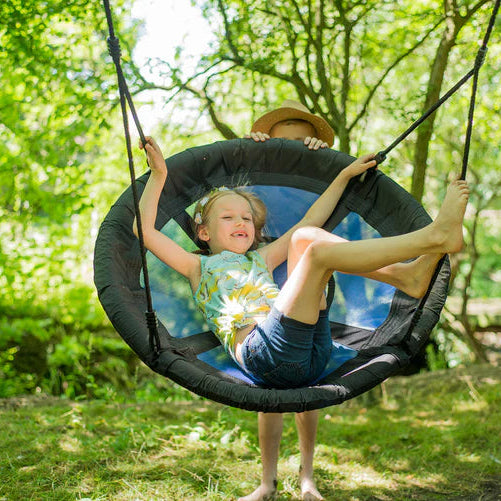 a-young-boy-happily-swinging-on-a-plum-spider-monkey-wooden-swing-set-in-a-backyard-setting