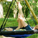 a-young-girl-smiling-while-swinging-on-a-green-seat-of-a-wooden-swing-set-outdoors