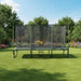 A ACON 16 HD Trampoline with a safety enclosure and ladder, placed on a grassy area outdoors.