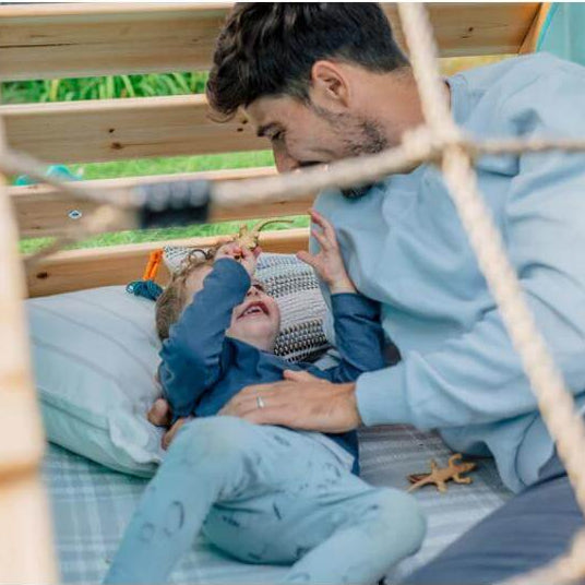 adult-and-child-lying-inside-play-tent-seen-through-rope-net