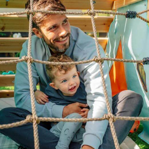 adult-and-child-sitting-inside-play-tent-behind-rope-net