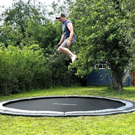 adult-bouncing-high-on-north-14ft-round-inground-trampoline-in-garden