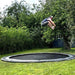 adult-doing-tuck-jump-on-north-14ft-round-inground-trampoline-in-garden
