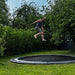 adult-jumping-on-north-round-inground-trampoline-in-garden