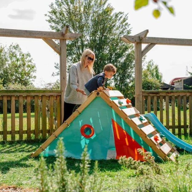 adult-supporting-child-on-triangular-playcentre-climbing-ramp-in-garden