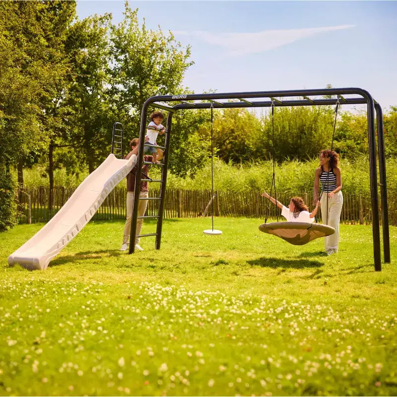 family-playing-on-berg-large-playbase-slide-and-swings