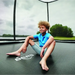 boy-sitting-relaxed-on-berg-trampoline-inside-safety-net-in-garden-image