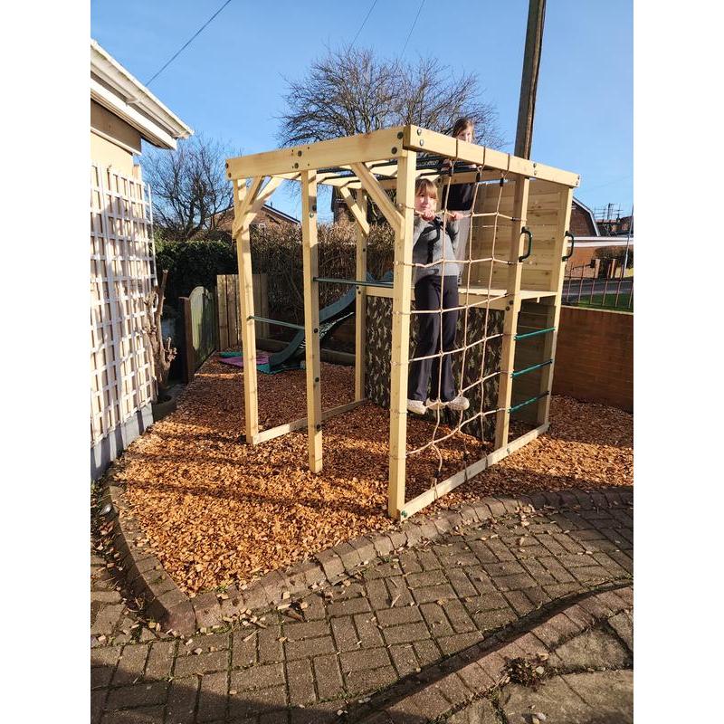 child-climbing-rope-net-on-wooden-climbing-cube-in-back-garden