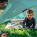 child-crawling-out-of-triangular-play-tent-with-adult-beside-entrance