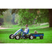 child-driving-a-blue-berg-pedal-go-kart-with-a-dog-in-the-trailer-in-a-park