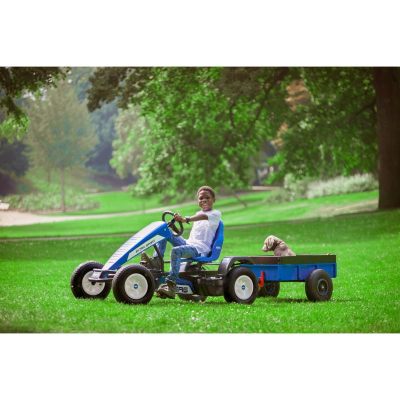 child-driving-a-blue-berg-pedal-go-kart-with-a-dog-in-the-trailer-in-a-park