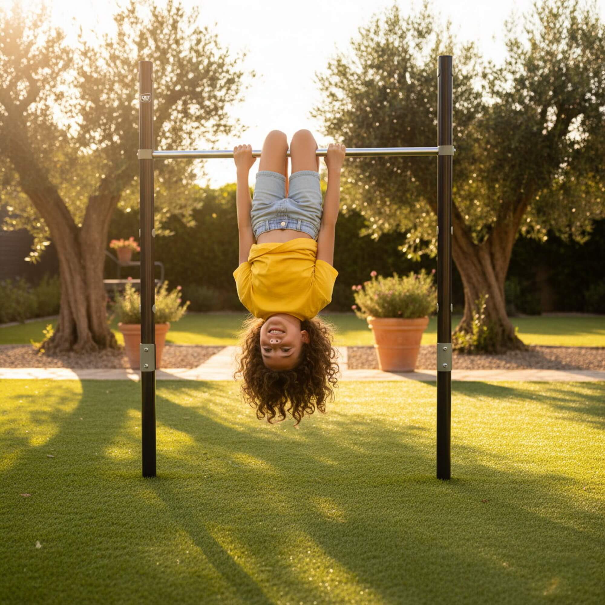 child-hanging-upside-down-on-exit-ivy-tumble-bar-in-sunny-garden