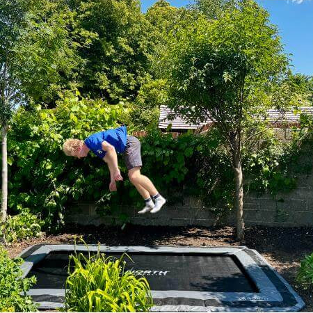 child-jumping-high-on-north-rectangular-inground-trampoline