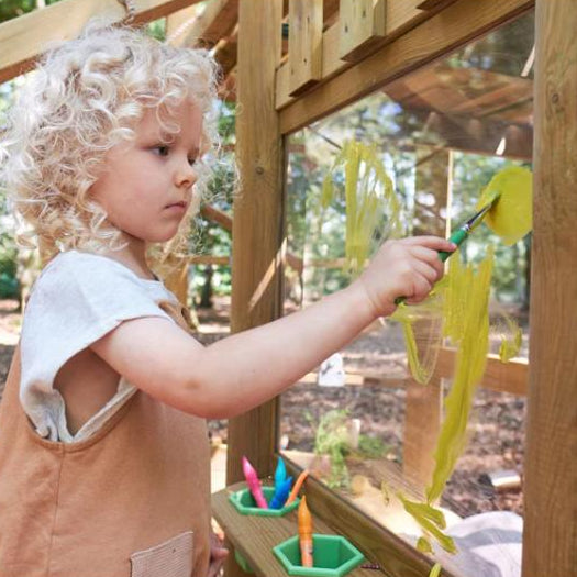 child-painting-yellow-shapes-on-clear-art-panel-of-wooden-playcentre