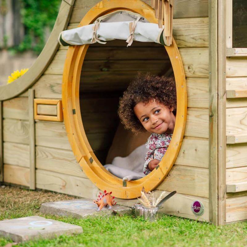 child-peeking-out-of-round-door-on-plum-discovery-nature-play-hideaway