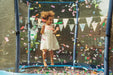 child-playing-with-confetti-in-blue-netted-trampoline