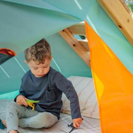 child-sitting-inside-triangular-play-tent-with-orange-door-flap