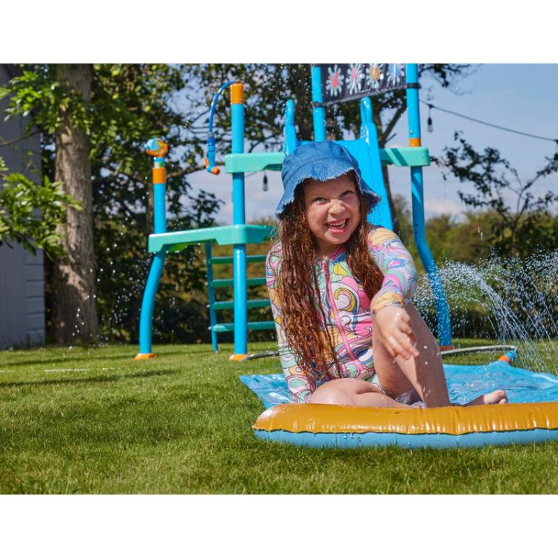 child-sitting-on-splash-mat-in-front-of-plum-play-water-park-shower-tower
