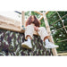 child-sitting-on-top-of-plum-wooden-climbing-cube-above-camouflage-fabric-wall