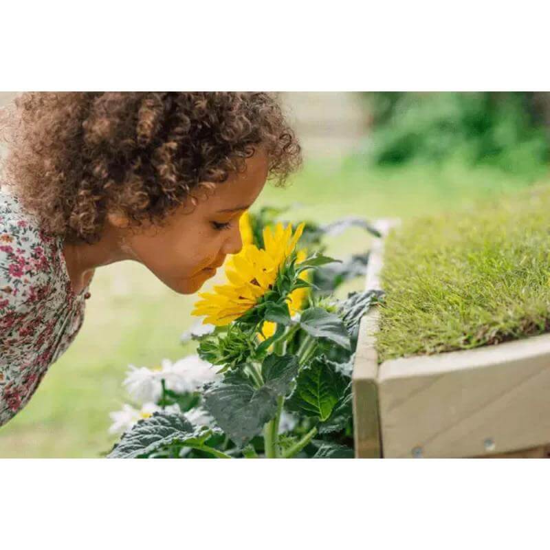 child-smelling-flowers-in-planter-on-plum-discovery-nature-play-hideaway