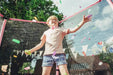 child-throwing-confetti-inside-pink-garden-trampoline