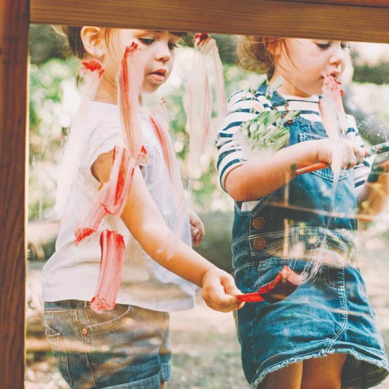 children-painting-on-clear-play-panel-at-wooden-playcentre