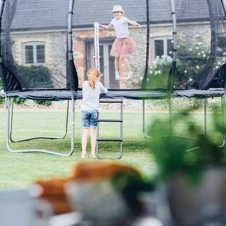 children-playing-on-plum-magnitude-trampoline-with-ladder-in-garden