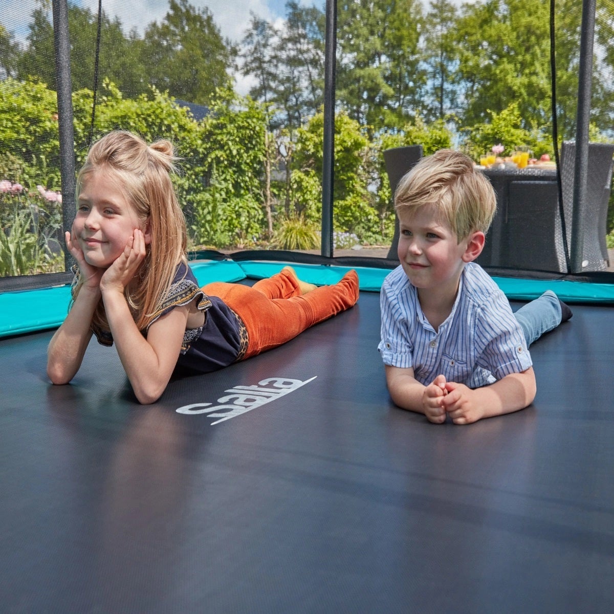 children-relaxing-on-salta-rectangular-trampoline-in-the-garden