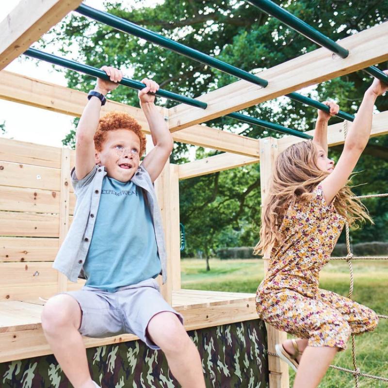 children-using-monkey-bars-on-wooden-climbing-cube