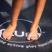 close-up-of-childs-feet-on-plum-trampoline-mat-logo