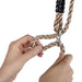 close-up-of-hands-demonstrating-height-adjustment-on-synthetic-hemp-swing-rope-using-metal-hardware