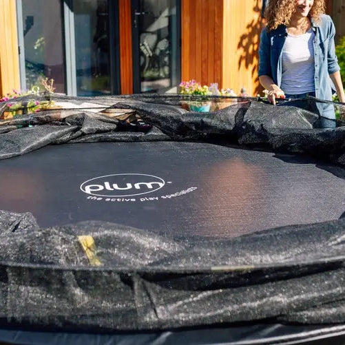 close-up-of-plum-spacezone-trampoline-mat-and-folded-enclosure-during-assembly