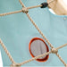 close-up-of-rope-climbing-net-in-front-of-blue-play-tent-side-panel-with-round-mesh-window