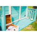 close-up-of-teal-playhouse-veranda-floor-with-tea-set-and-open-storage-box