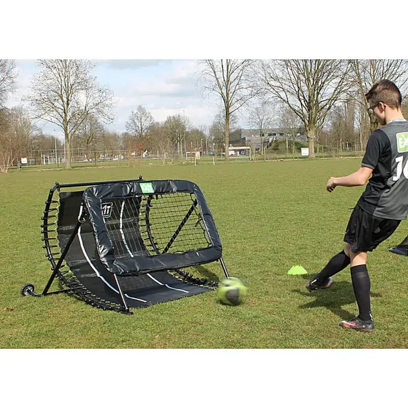 lifestyle-view-of-exit-football-rebounder-with-teen-kicking-ball