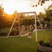 exit-toys-silvi-wooden-swing-set-with-two-children-swinging-at-sunset-in-garden_2582159b-44fe-4d97-bef7-0522636d24c0