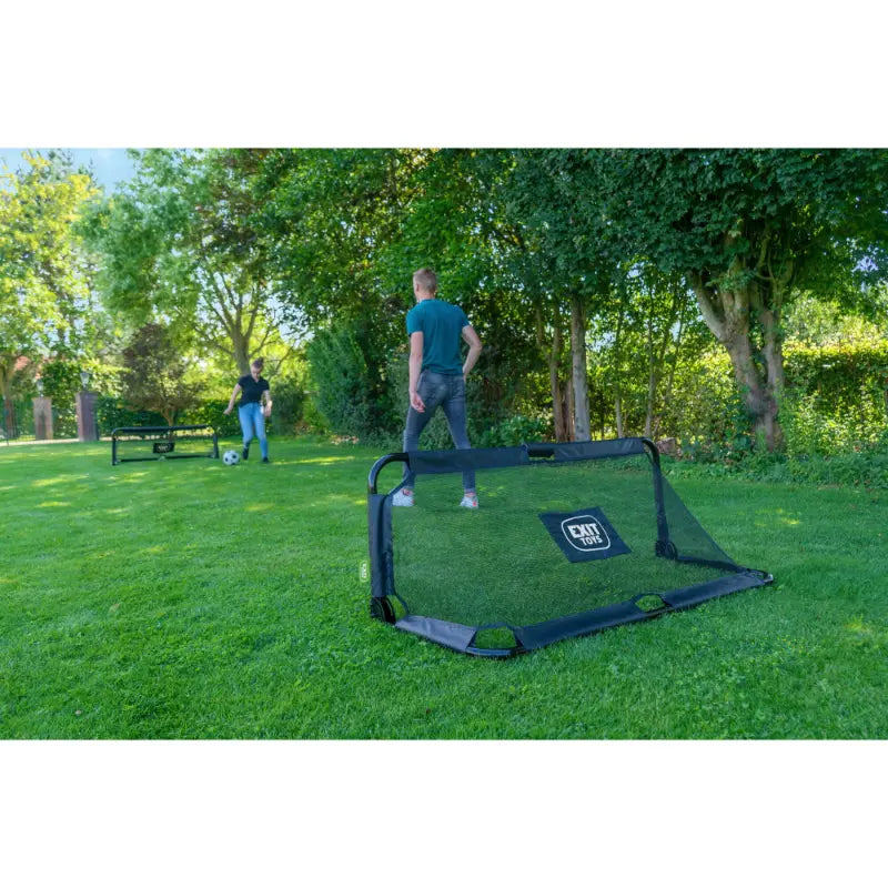 family-playing-with-exit-panna-kids-football-goal-set-for-home-use-with-trees-in-the-background