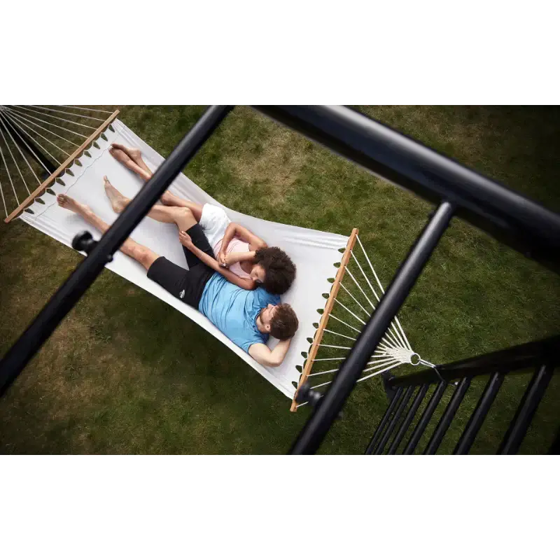 family-relaxing-together-on-hammock-attached-to-outdoor-play-frame-in-garden