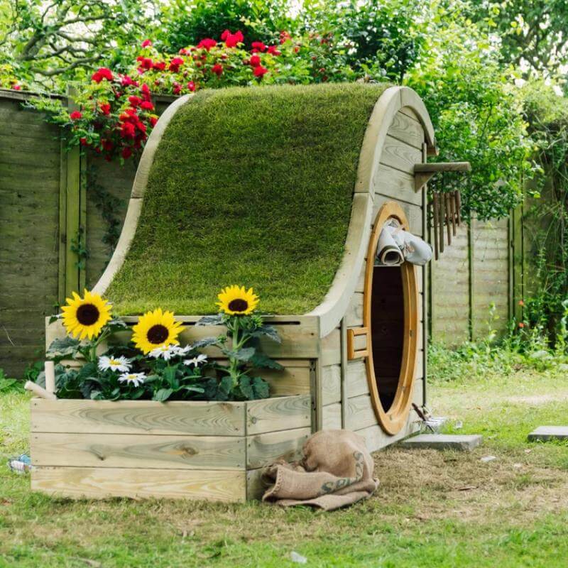 front-view-of-plum-discovery-nature-play-hideaway-with-grass-roof-and-planter_6056006e-fd53-4b0a-8c45-a8de40aa5333