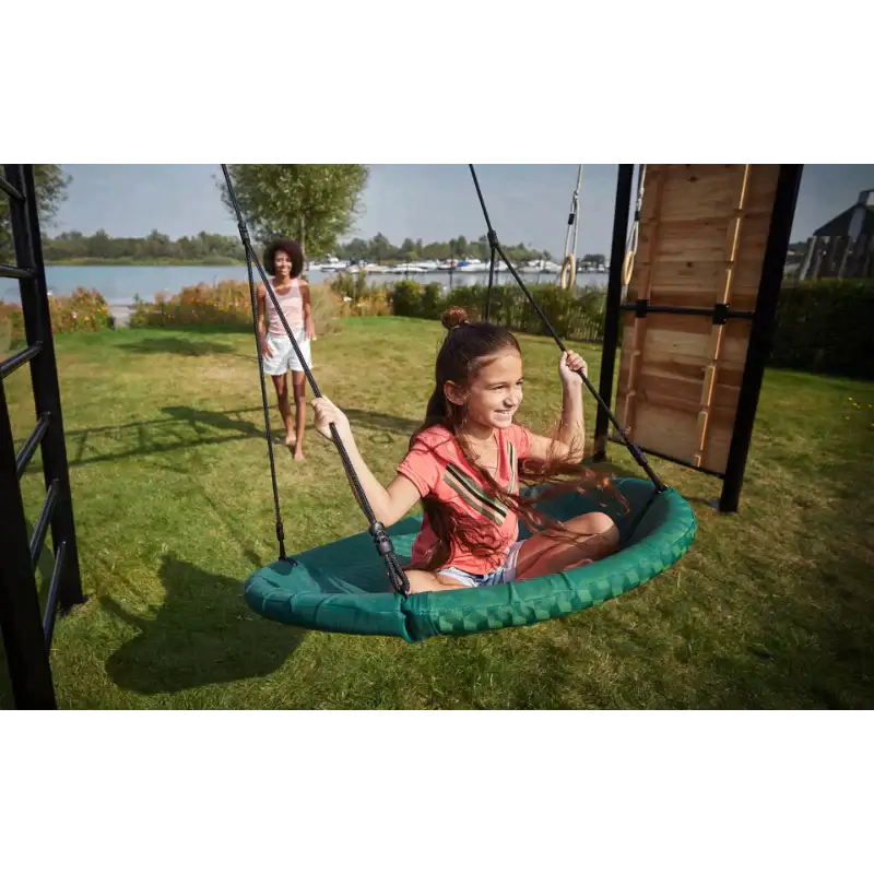 girl-riding-nest-swing-on-outdoor-play-frame-in-garden