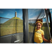 girl-standing-at-berg-trampoline-safety-net-entrance-with-grassy-hill-in-background