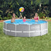 front-view-of-intex-model-a-12x39-swimming-pool-with-prism-frame-and-durable-material-liner-and-placed-on-the-lawn-with-family-playing-with-inflatable-ball