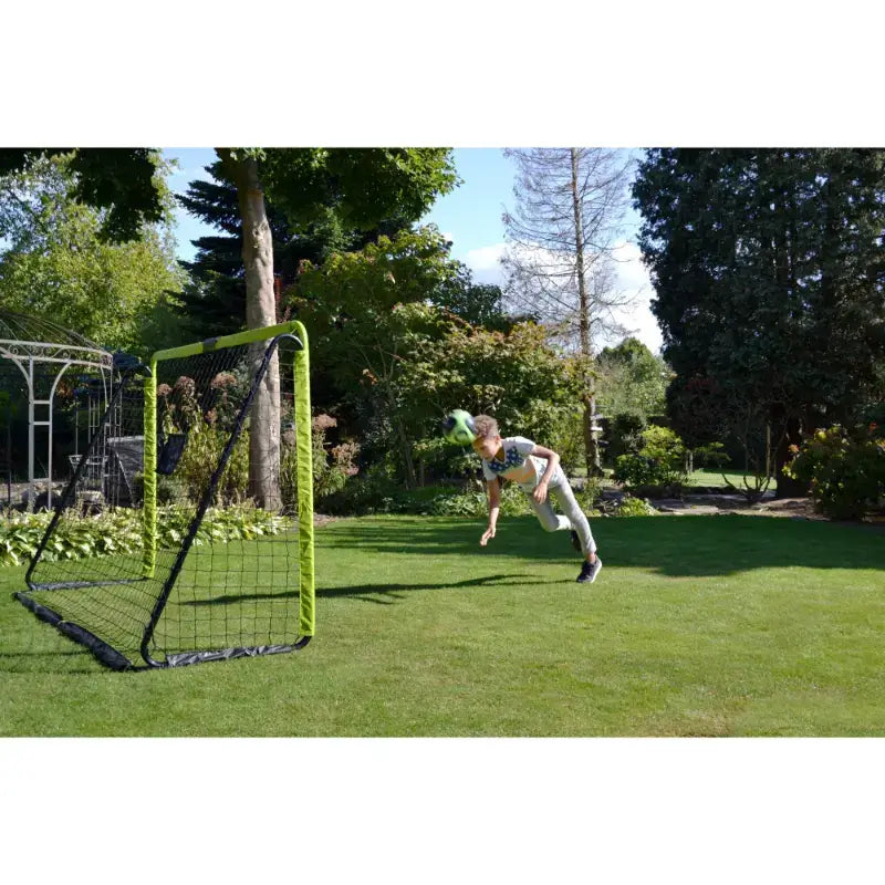 Lifestyle shot of a kid hitting football ball towards EXIT Tempo football goal.