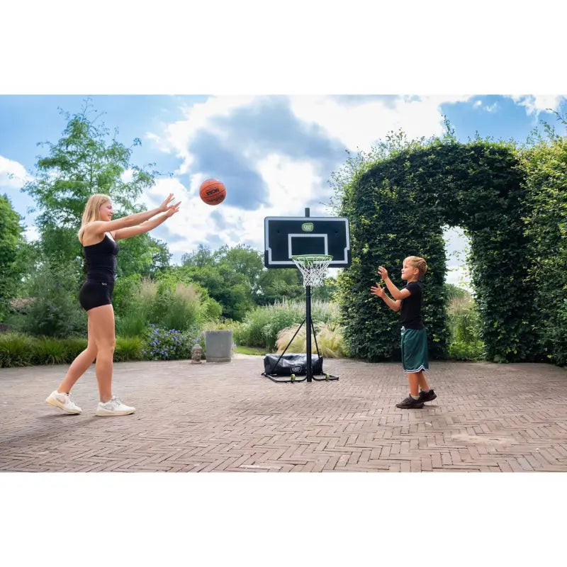 lowered-height-exit-novastar-adjustable-basketball-backboard-outdoor-setup-with-bush-in-the-background